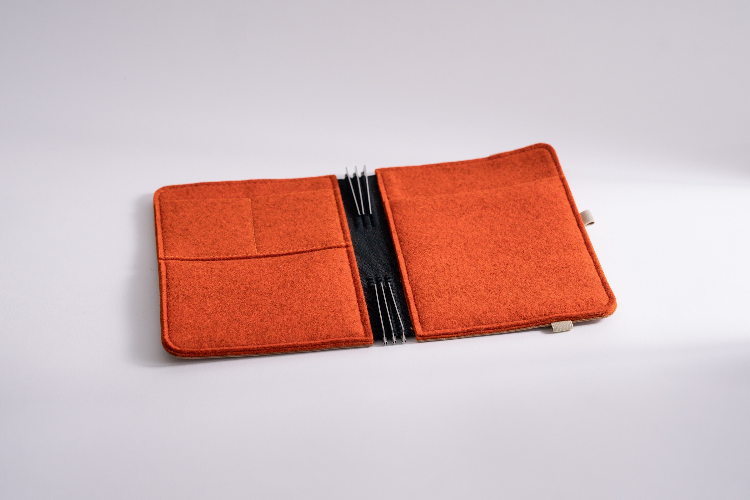 Taschenbegleiter LTD_029 im Format M, mit rostorangem Filz innen und hellem braunem Leder außen mit Verschlussgummi.